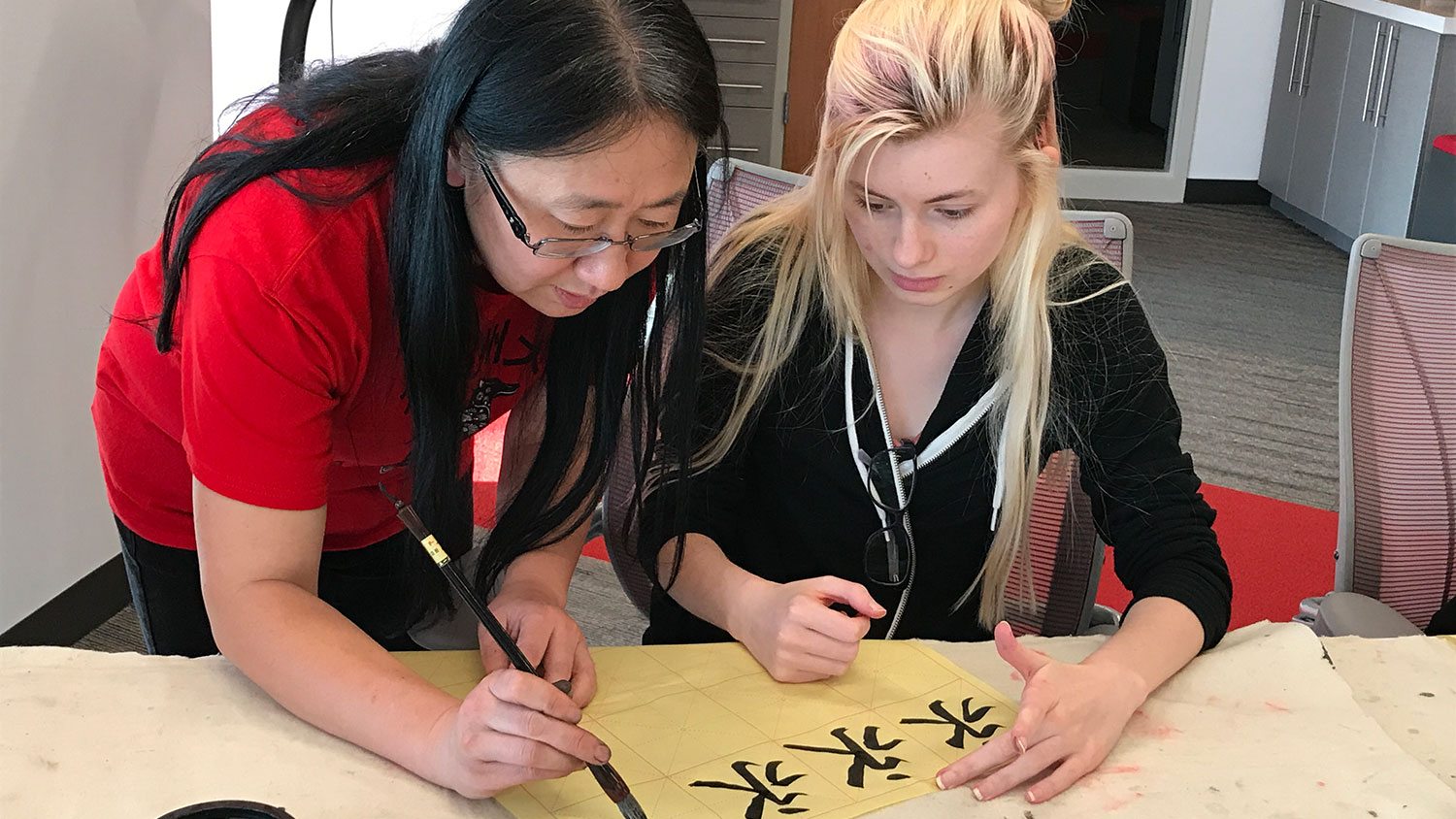 Woman demonstrating Asian calligraphy