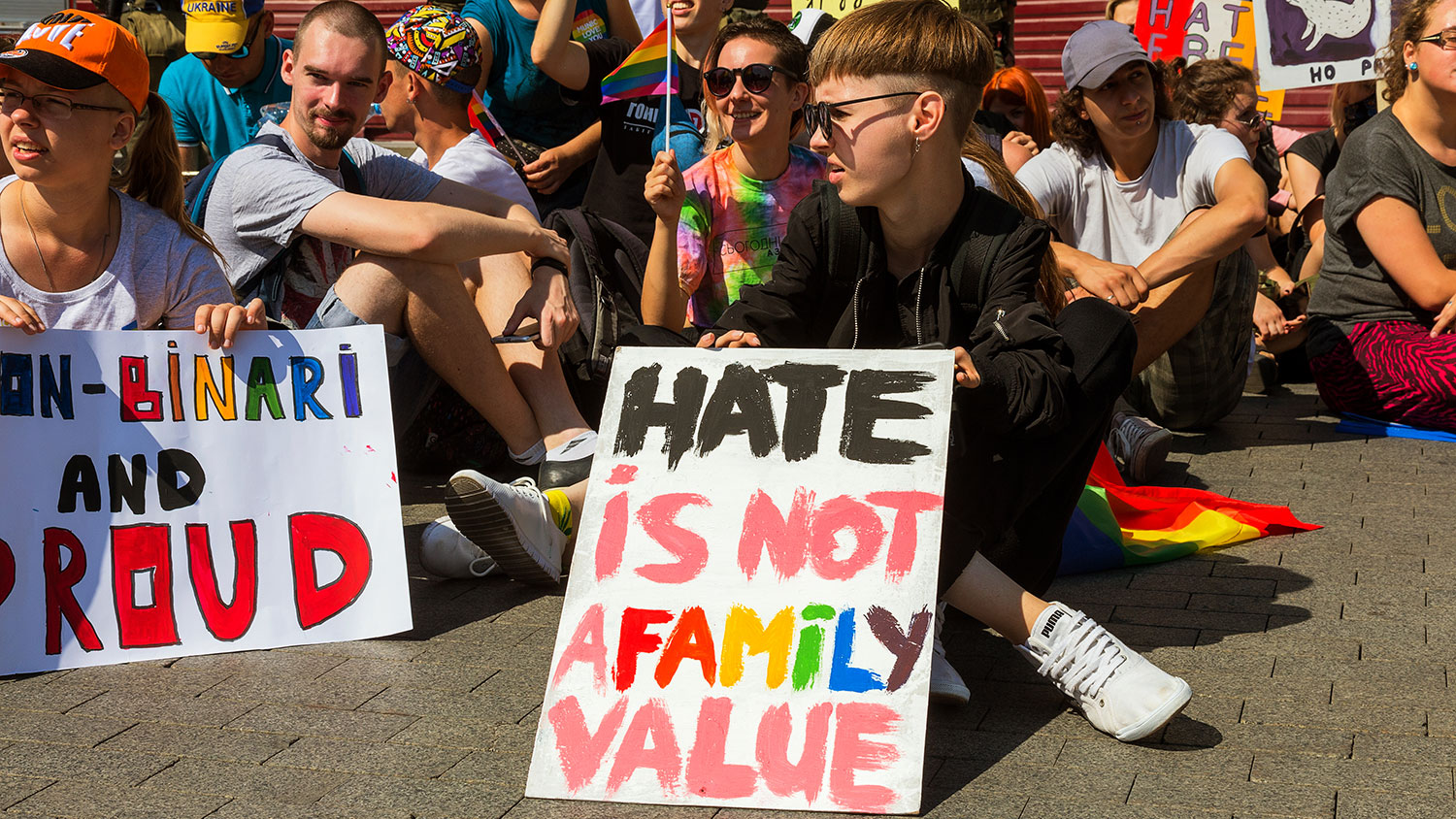 Student protesting with sign saying "Hate is not a family value."