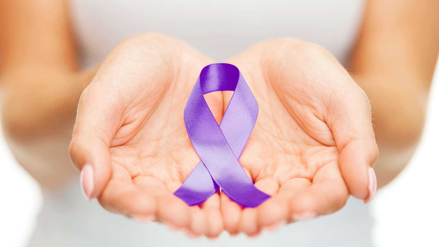 Hands holding purple ribbon