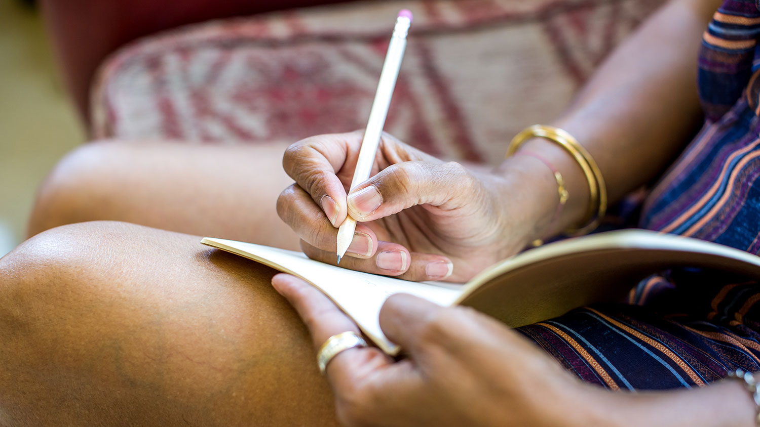 Woman taking notes in notebook on lap