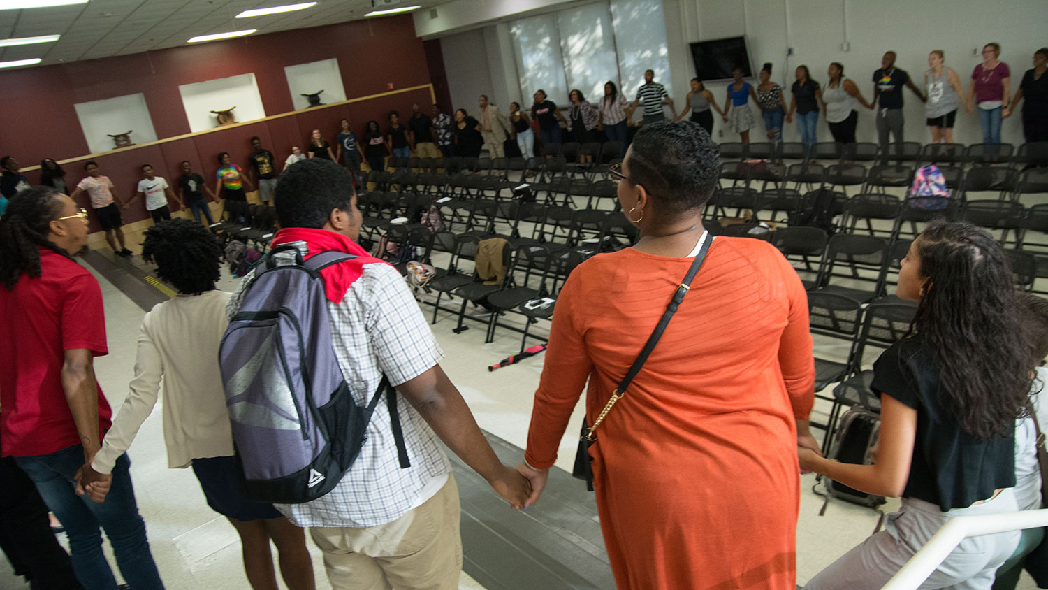 Participants join hands at Harambee