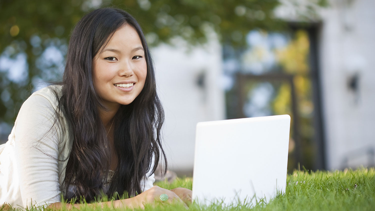 Smiling girl outside with laptop