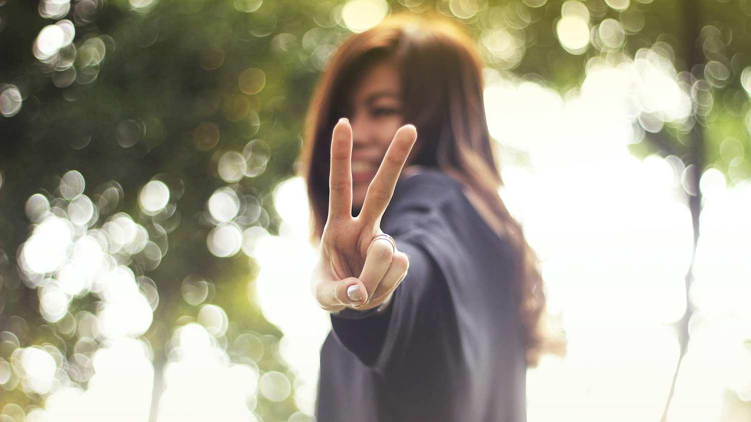 Asian woman flashing "V" sign