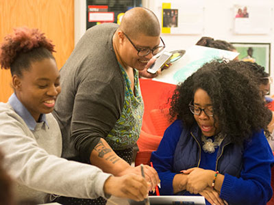 Artist Gemynii assists a painting workshop participant