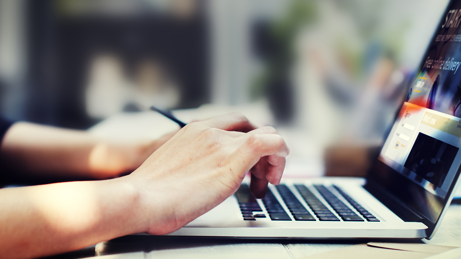 Hands typing on a laptop